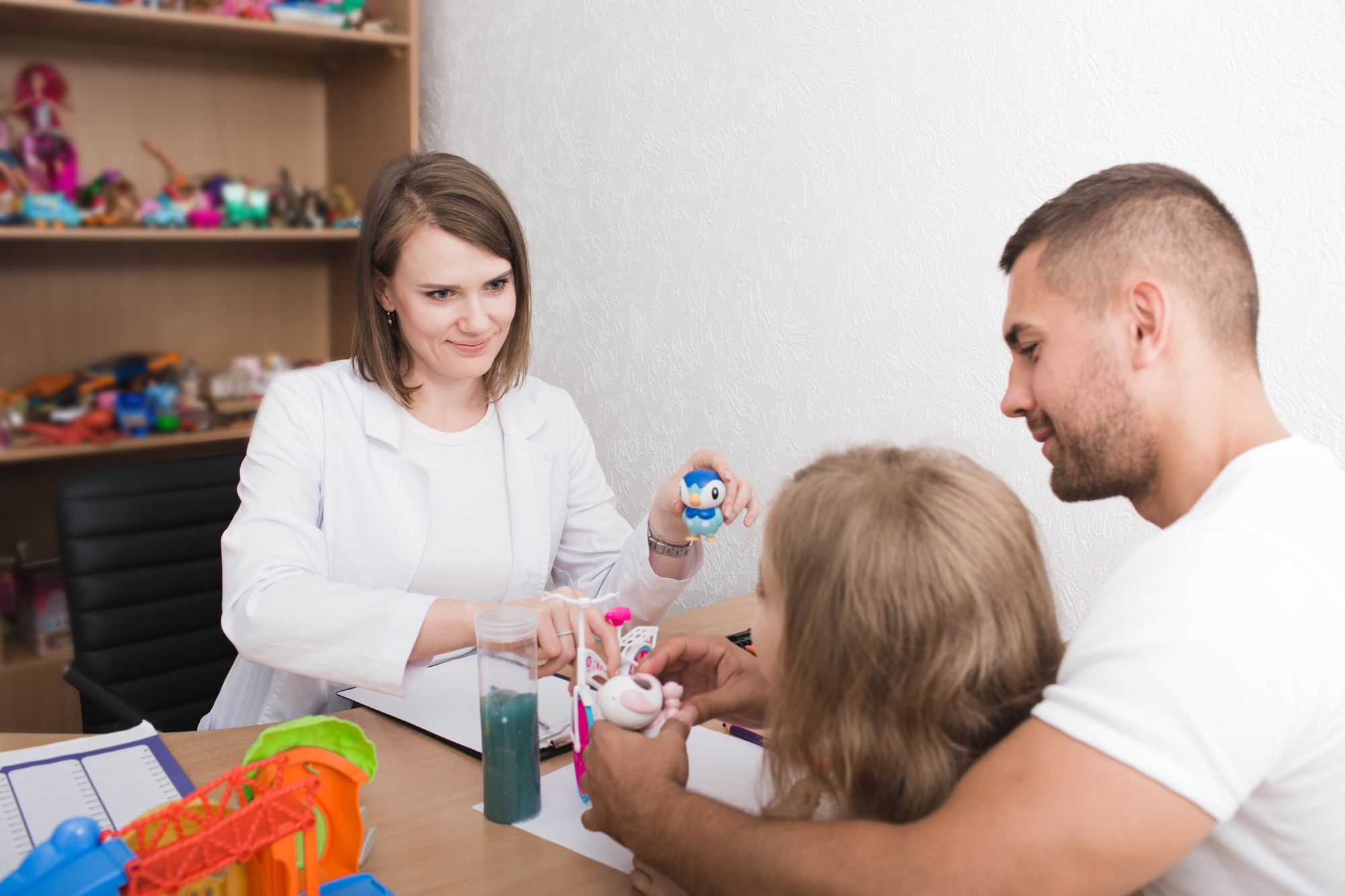 Child psychologist talks with a child and father in the office of a child psychologist