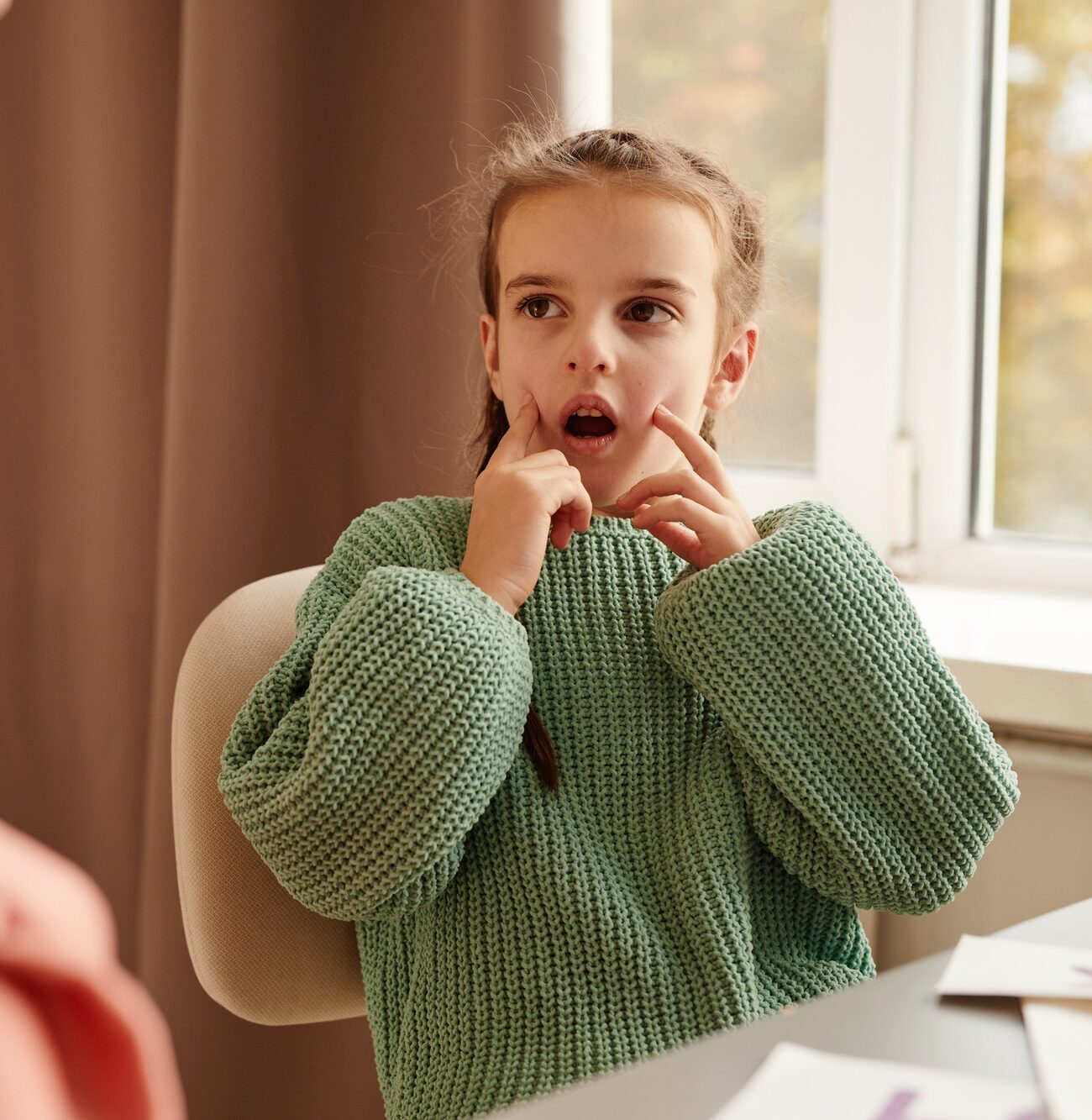Little girl learning articulation with teacher